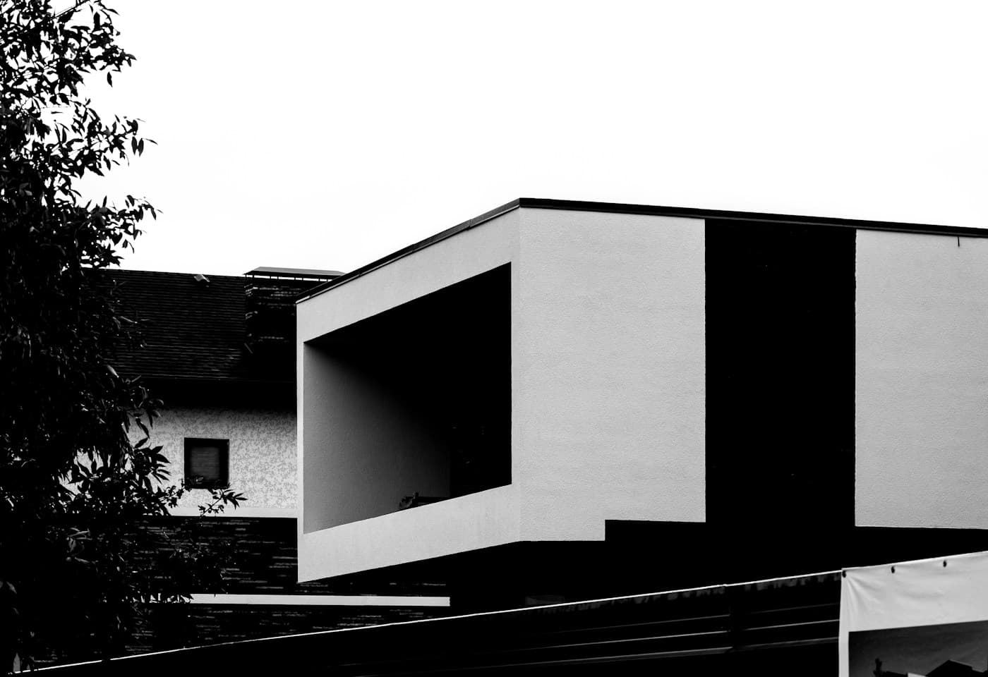 Black-and-white photograph of a modern house with clean rectangular forms, by Ronan Furuta.
